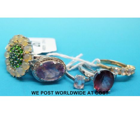 Four silver rings, one set with opals and peridot, one ruby, one amethyst and a pink quartz together with a silver gilt ring 