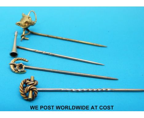 Four yellow metal stick pins, one in the form of a hunting horn, another in the form of a fox and whip 