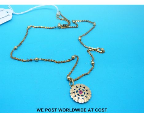 A yellow metal necklace with sphere decoration and pendant set with a ruby (7.1g)