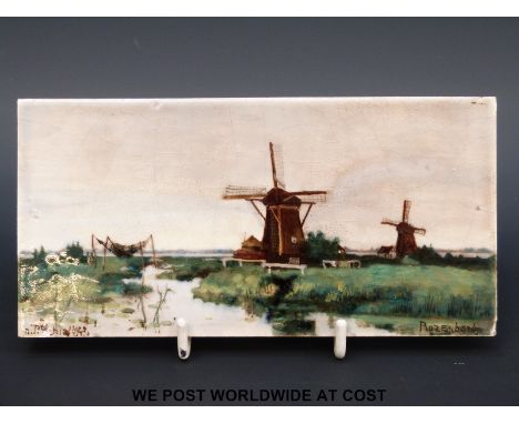 Rozenburg den Haag hand painted ceramic tile, signed bottom left, depicting a Dutch scene of windmills by a river, marked to 