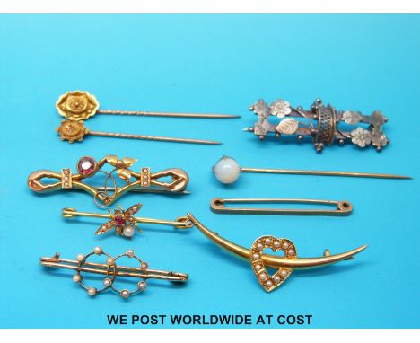 Two Victorian stick pins marked 15ct, another stick pin set with an opal, five yellow metal brooches set with seed pearls, on