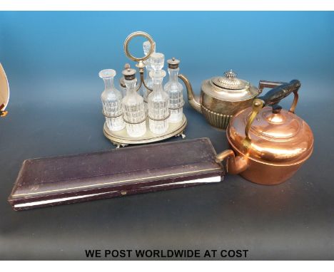 A six bottle cut glass cruet on silver plated stand, plated teapot, copper kettle and a cased carving set 