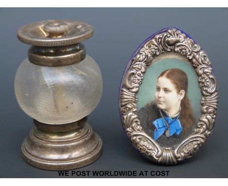 A hallmarked silver miniature picture frame with hand decorated miniature of a lady together with a white metal mounted peppe