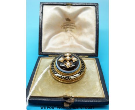 A cased Victorian mourning brooch set with a banded agate cabochon and seed pearls surrounded by black enamel, hair compartme