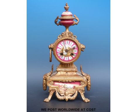A French gilt mantel clock with Sevres style panel, two train movement and decorative cherub feature finial, 35cm tall, raise