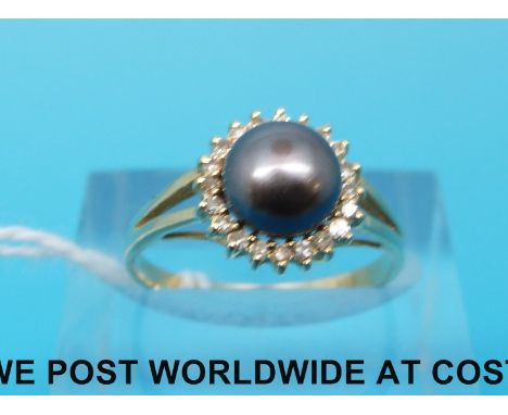 A yellow metal ring marked 585 set with a black Venetian pearl surrounded by diamonds (size L)