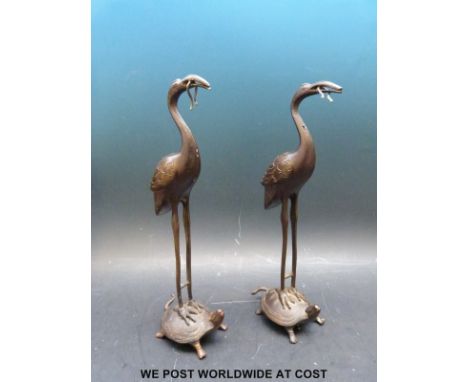 A pair of Chinese bronze storks with snake in beak and standing on a turtle, height 16.5cm