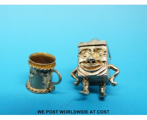 Two 9ct gold charms, one a tankard with the remains of enamel decoration, the other a cube with human face, arms, legs and hi