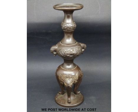 A bronze bud vase / incense holder, raised on masked feet, height 18.5cm