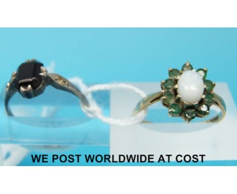 A 9ct gold ring set with an opal and emeralds and a 9ct gold and silver ring set with a garnet 