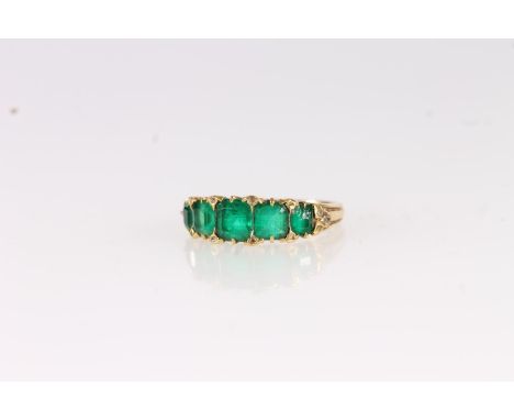 Victorian yellow gold ring set with five graduating square cut emeralds, interspersed with rose cut diamond chips on a groove