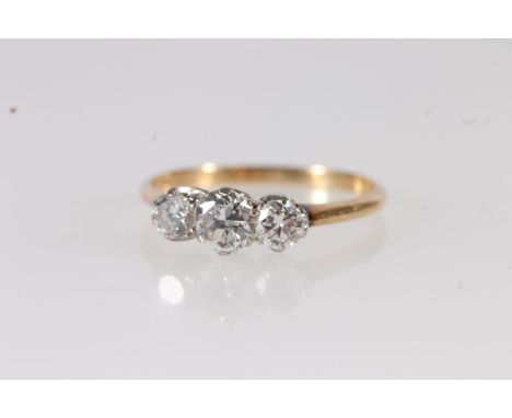 18ct gold and three stone diamond trilogy ring, the brilliant round cut diamonds on platinum setting leading to tapered gold 