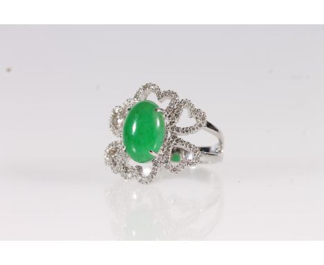 18ct white gold Jade and diamond ring, the oval cabochon jade stone flanked by a cluster of small round cut brilliants in hea