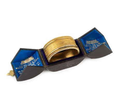An Archaeological Revival gold bangle, of hinged oval form, applied to the front with a frieze of ropetwist, wirework and bea