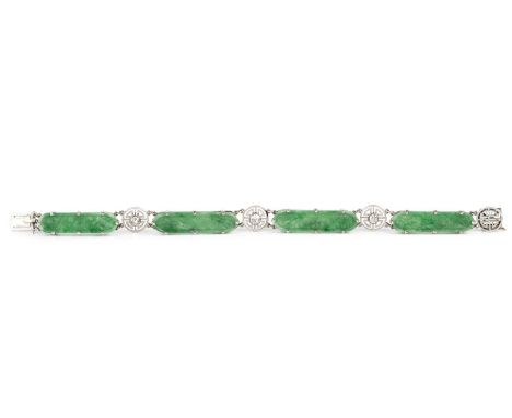 An Art Deco jade and diamond panel bracelet, designed as a series of carved elongated oval jadeite batons, spaced by a trio o