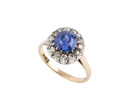 A sapphire and diamond cluster ring, the circular mixed-cut sapphire claw set within a border of old-cut diamonds, above a sc