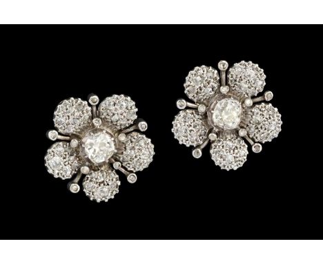 A pair of 'day and night' diamond flowerhead earrings, each centred with a cushion-shaped old-cut diamond stud in pinched col