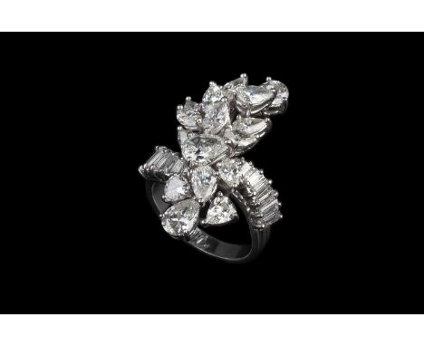 A diamond cocktail ring, designed as a tiered cluster of pear and marquise-cut diamonds in claw settings, between graduated b