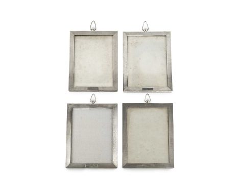 A set of four George V silver rectangular photograph frames, with engine turned decoration, vacant cartouches and shaped susp