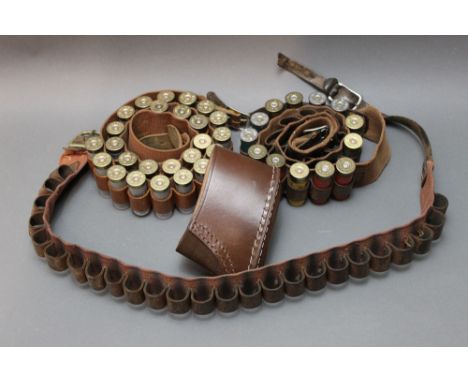 +/- Thirty 12 bore shotgun cartridges, various makes, various sizes, together with three cartridge belts and a leather stock 