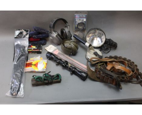 A box containing a Z-Aim Pro Stalker Big Five sling, various hand warmers, ear defenders, lamp, cartridge belts, scope, Titan