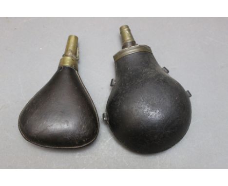 *  A leather bodied powder flask, length 20 cm, together with a leather bodied shot flask, length 17 cm.