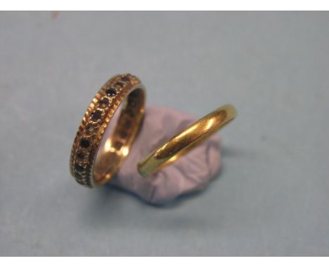 A large 22ct. gold band wedding ring, 4.7 grams, size W/X and a large 9ct. gold eternity ring, set ruby and diamond chips, si