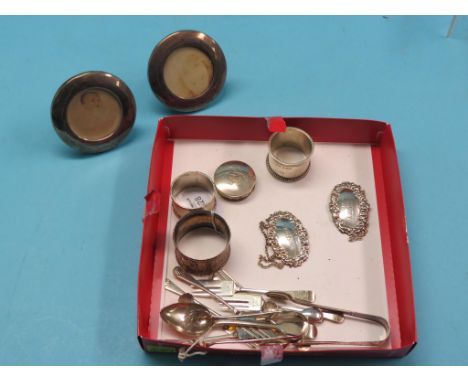 A pair of small circular silver portrait photograph frames, two silver napkin rings, circular monogrammed silver box, pair of
