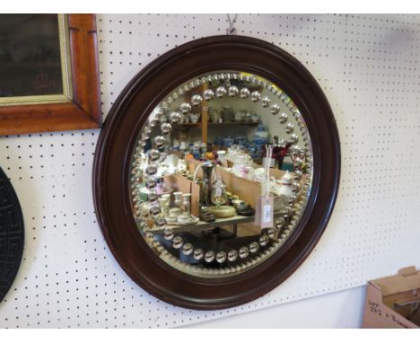 A 19th century Irish novelty convex mirror, circumference set with numerous convex reflections, moulded walnut frame, 23in.