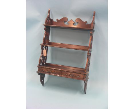 A Chippendale-style mahogany shelf unit, three shelves and lattice-work ends, two short drawers beneath, 1ft. 9in.
