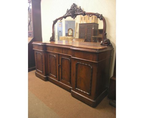 A large mid-Victorian mahogany sideboard, domed mirror back with carved grape and vine-leaf cresting, three frieze drawers ab
