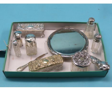 An embossed silver hand mirror, Birmingham 1906, and other silver-mounted dressing table accessories, ten total