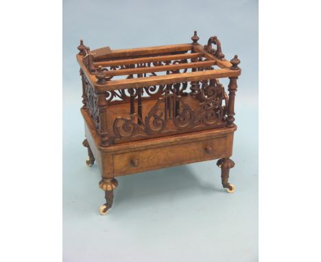 A Victorian burr walnut Canterbury, scroll fretwork around three divisions, base drawer, on turned legs with ceramic casters,