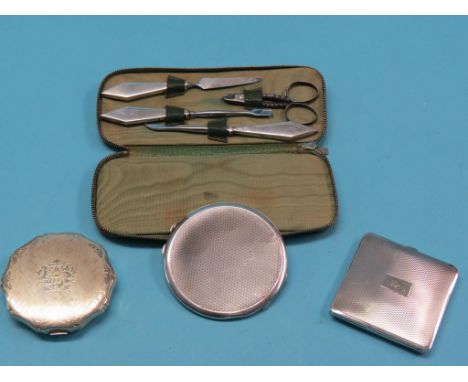 An Art Deco engine-turned silver compact, Birmingham 1934, two other silver compacts and a silver manicure set, in folding ca