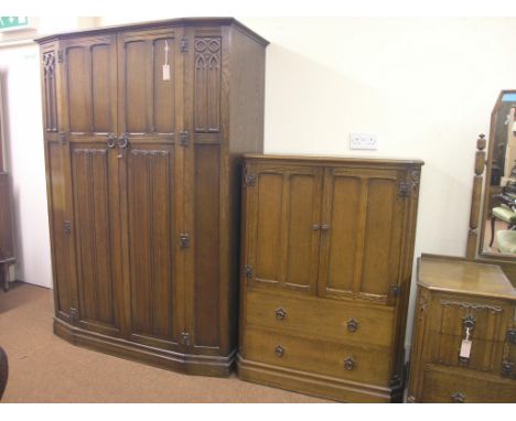 A dark oak bedroom suite, panelled wardrobe enclosed by pair of full-length doors, 4ft. 2in., dressing table with framed adju