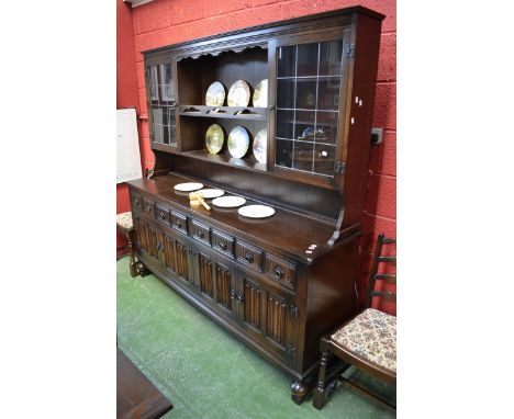 A large modern Miss Tudor oak dresser, supplied by Iron Gate Furnishings, Derby, stepped cornice, two shelves flanked by lead