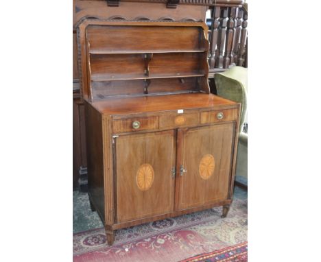 A mahogany commode, fan shaped cartouche to top, dentil frieze, canted and fluted angles, the hinged top opening to form a tw