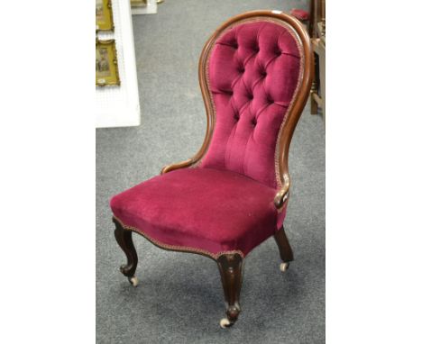 A Victorian mahogany spoon back nursing chair, button upholstery, serpentine stuffed overseat, cabriole foreleg, scrolling fe