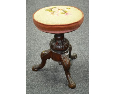 A Victorian mahogany adjustable piano stool, circular padded top, turned column, carved cabriole legs.