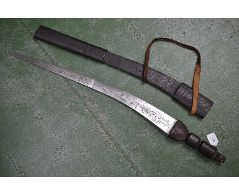 A Sudanese sword, the blade engraved with foliate curves, tooled leather scabbard