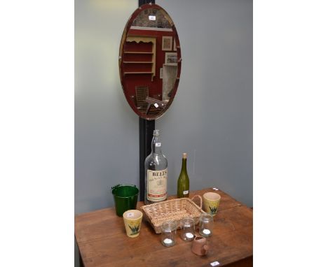 A large Bells whisky bottle; a flower bucket; a vintage oval mirror; two flower pots; a wicker basket; three tea light holder