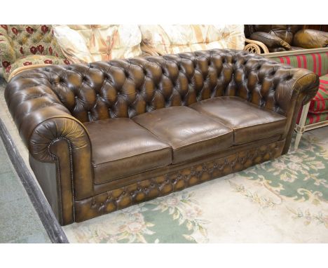 A brown leather Chesterfield sofa with button back.