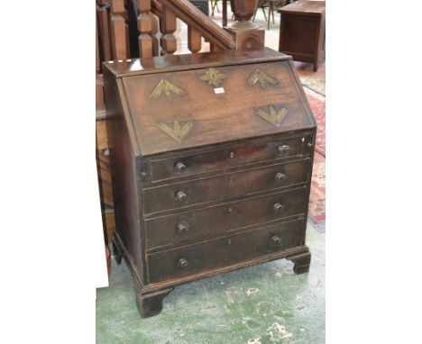An early 19th century mahogany bureau, the brass mounted fall front enclosing an arrangement of drawers and pigeonholes, four
