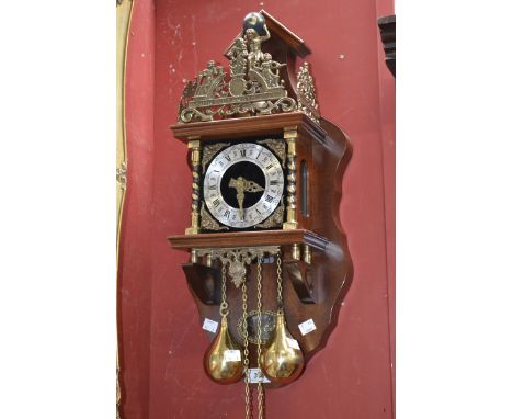 A Franz Hermle atlas wall clock, mahogany case with figural Atlas holding the world finial and other ornate metal decoration.