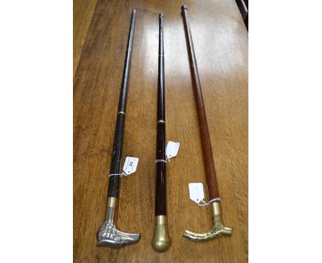 A 20th century ebonised and brass walking stick, eagle handle; others, one with drinks phial, brass grips.