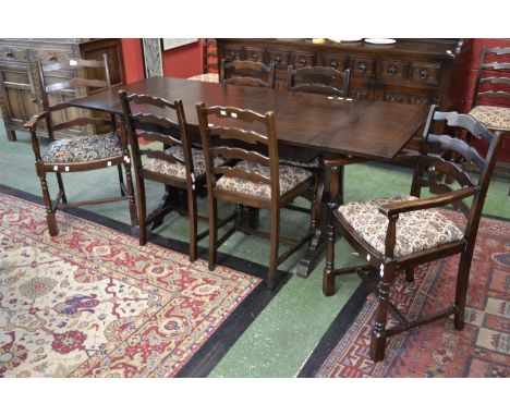 A dark oak drawleaf extending dining table and eight ladder back chairs