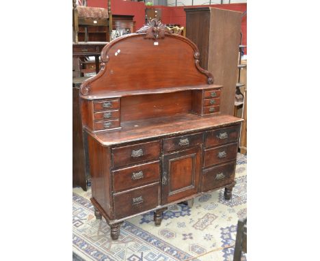 A Victorian pine chiffonier with arched back with shelf and six small drawer, projecting base, an arrangement of seven drawer