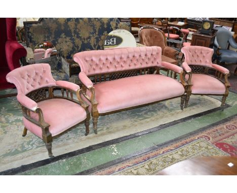 A Victorian mahogany salon suite comprising scrolling button upholstered back, fretworked splat, padded spindled arm rail, st
