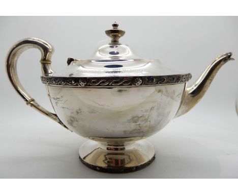 A silver teapot, Glasgow 1925, of tapering circular form with a band of Celtic decoration, bears an inscription, 16cm high, 8