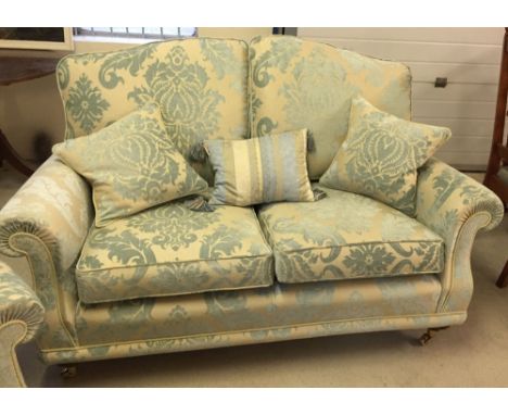 A reproduction Victorian 2 seater sofa in cream & blue damask upholstery with wooden & brass legs, in excellent condition.